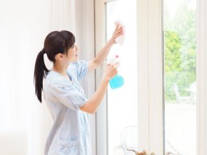 大きな窓を掃除する女性